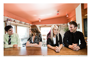 people sitting at a communal table in a cafe